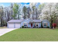 Charming one-story home with a two-car garage and a well-manicured lawn, showcasing its inviting curb appeal at 603 Bluff Dr, Woodstock, GA 30188