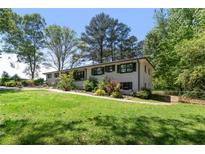 Inviting exterior featuring a well-maintained lawn and charming white-painted brick at 3501 Wesley Chapel Rd, Decatur, GA 30034