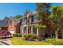 Charming two-story brick home with well-manicured lawn, red roses, and mature trees at 2296 Valley Brook Ne Way, Atlanta, GA 30319