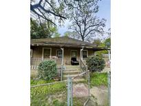 Quaint one-story home with covered porch and mature trees offers a cozy curb appeal at 6158 Cooper St, Douglasville, GA 30134