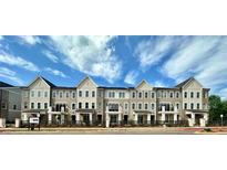 Charming new townhome community with craftsman-style architecture and lush landscaping against a blue sky at 556 Sawnee Village Blvd # D76, Cumming, GA 30040
