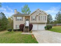Charming two-story home with stone accents, attached garage, and landscaped front yard at 313 Daniel Mill Xing, Villa Rica, GA 30180