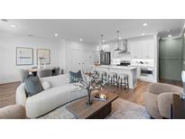 Bright, open-concept living room features a modern kitchen with stainless steel appliances and a cozy seating area at 554 Sawnee Village Blvd # D75, Cumming, GA 30040