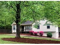 Charming home with a well-maintained front yard, mature tree, mulch bed, and a cozy front porch at 647 Sunshine Nw Trce, Acworth, GA 30102