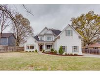 Charming two-story white brick home with a manicured lawn and inviting front porch at 1515 Walker Ave, Atlanta, GA 30337