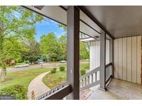 Inviting porch with view of a beautifully landscaped front yard and quiet residential street at 5429 Golfcrest Cir, Stone Mountain, GA 30088