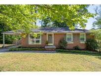 Charming brick ranch home featuring well-maintained landscaping and a convenient covered carport at 573 Lyle Se Dr, Marietta, GA 30067