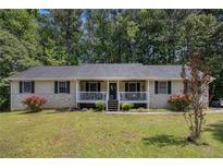Charming single-story home with a cozy front porch and a well-manicured lawn surrounded by mature trees at 258 Cristy Dr, Dallas, GA 30157