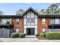 Apartment building featuring a brick facade, and an inviting front entrance with well maintained landscaping at 6851 Roswell Rd # A-12, Atlanta, GA 30328