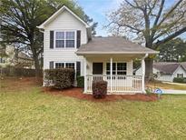 Charming two-story home with landscaped yard, inviting front porch, and classic architectural details at 7747 Rountree Xing, Riverdale, GA 30274