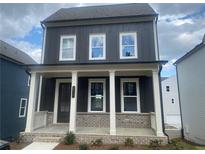 Charming two-story home featuring dark siding, white trim, a welcoming front porch, and beautiful landscaping at 2725 Creek View Nw Ter, Atlanta, GA 30318