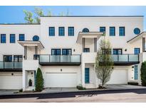 Modern townhome featuring white brick, private balconies, garage, and stylish architectural details at 1337 Grey Fox Ne Ct, Atlanta, GA 30306