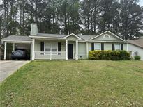 Charming one-story home with a quaint front porch and a convenient carport for covered parking at 6490 Emerald Pointe Circle, Atlanta, GA 30349