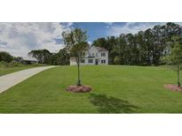 Expansive front lawn and two story traditional home, painted white with black shutters at 2740 Byess Ct, Marietta, GA 30064