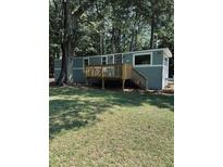 Inviting single-story home featuring a wood deck, a gray exterior, and mature trees at 5400 Kings Camp Rd, Acworth, GA 30102