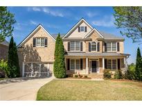 Inviting two-story brick home with a well-manicured lawn and a two-car garage at 5650 Upper Creek Ct, Suwanee, GA 30024