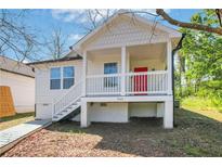 Charming cottage-style home with a red front door and elevated porch, perfect for enjoying the outdoors at 944 Joseph E Boone Nw Blvd, Atlanta, GA 30314