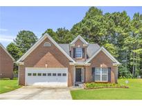Charming single-story brick home with attached garage, landscaped yard, and lush green trees surrounding at 1211 Liverpool Pointe, Lawrenceville, GA 30046