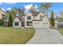 Charming two-story home with a manicured lawn and a two-car garage at 5485 Woodrun Ln, Johns Creek, GA 30005