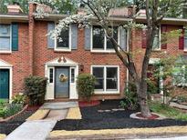 Charming brick townhome with well-manicured landscaping and a welcoming front entrance at 908 Chippendale Ln, Norcross, GA 30093
