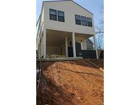 Modern two-story home with a light exterior, dark accents, and a unique elevated design, creating an inviting curb appeal at 996 Camilla St, Atlanta, GA 30314