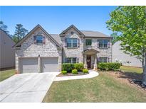 Charming two-story brick home with well-manicured lawn and attached two-car garage at 225 Mary Jane Ln, Covington, GA 30016