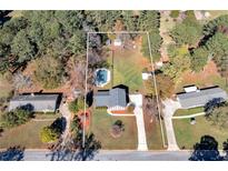 Sprawling property featuring a lovely in-ground pool and a charming home surrounded by lush trees and green space at 313 Fayette Villa Ct, Fayetteville, GA 30214