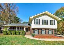 Charming two-story home with manicured lawn, brick accents, and inviting front porch at 313 Fayette Villa Ct, Fayetteville, GA 30214