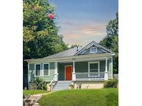 Charming craftsman-style home with a welcoming front porch, a well-manicured lawn, and a vibrant orange front door at 693 Dill Sw Ave, Atlanta, GA 30310