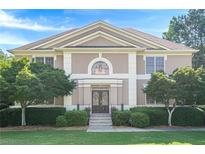 Elegant two-story home with a symmetrical facade, manicured lawn, and mature landscaping at 7415 Northampton Ct, Cumming, GA 30040