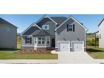 Charming two-story home with a two-car garage, manicured lawn, and gray wood siding, creating a welcoming curb appeal at 13244 Tolstoy, Covington, GA 30014