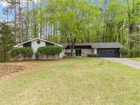 Charming single-story home featuring a manicured lawn and mature trees in a serene, residential neighborhood at 4595 Fradon Ct, Atlanta, GA 30349