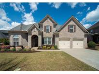 Charming brick home featuring a manicured lawn, two-car garage, and an inviting front entrance at 2557 Staunton Dr, Duluth, GA 30097