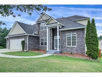 Charming two-story home featuring stone accents, a well-manicured lawn, and a classic architectural design at 6793 Oconee Pl, Fairburn, GA 30213