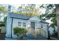 Charming house features a light blue exterior, stone chimney, and a welcoming front porch at 2022 Detroit Ave, Atlanta, GA 30314