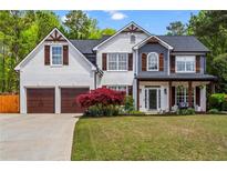 Charming two-story home with a manicured lawn, inviting front porch, and a two-car garage at 904 Beaumont Ct, Canton, GA 30114
