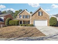 Charming two-story brick home with a well-manicured lawn, white garage door, and a classic, inviting entrance at 2130 Cooper Lakes Dr, Grayson, GA 30017