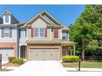 Charming townhouse with a two-car garage, manicured lawn, and inviting curb appeal at 2436 Sardis Chase Ct, Buford, GA 30519