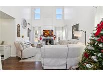 Cozy living room featuring soaring ceilings, a fireplace, and comfortable seating with a view to the backyard at 1240 Birchwood Ln, Roswell, GA 30076