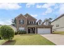 Charming brick two-story home with manicured lawn and attached two-car garage at 1612 Nations Trl, Riverdale, GA 30296