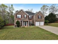 Charming brick two-story home with a manicured lawn, a two-car garage, and mature landscaping at 159 Molly Way, Mcdonough, GA 30253