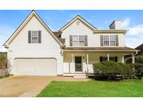 Charming two-story home with a well-maintained lawn, attached two-car garage, and a welcoming front porch at 4437 James Wade Dr, Snellville, GA 30039
