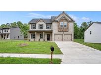 Charming two-story home featuring a brick facade, covered porch, two-car garage and well-maintained front yard at 370 Granary Walk, Covington, GA 30014