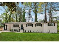 Charming renovated home with a well-manicured lawn, painted white brick, and stylish black trim at 307 Gordon Woods Sw Dr, Mableton, GA 30126