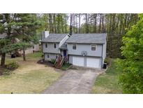 Two-story gray home with a two-car garage and well-maintained lawn with a driveway and basketball hoop at 175 W Station Nw Dr, Kennesaw, GA 30144