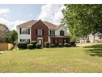Charming two-story home with brick and siding, a green lawn and mature trees at 3019 Havenwood Way, Stonecrest, GA 30038