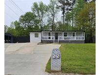Charming single-story home with a covered front porch and a well-maintained lawn at 1506 Ravenel Rd, Conley, GA 30288