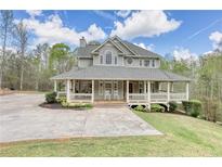 Charming two-story home with a sprawling front porch and a well-manicured lawn at 7746 Tyree Rd, Winston, GA 30187