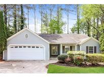 Charming single-story home featuring a well-manicured lawn, complemented by mature trees and colorful landscaping at 3472 Erin Nw Gln, Kennesaw, GA 30152