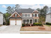Beautiful two-story home with manicured lawn, a two car garage and covered front porch entry at 4495 Alister Park Dr, Cumming, GA 30040